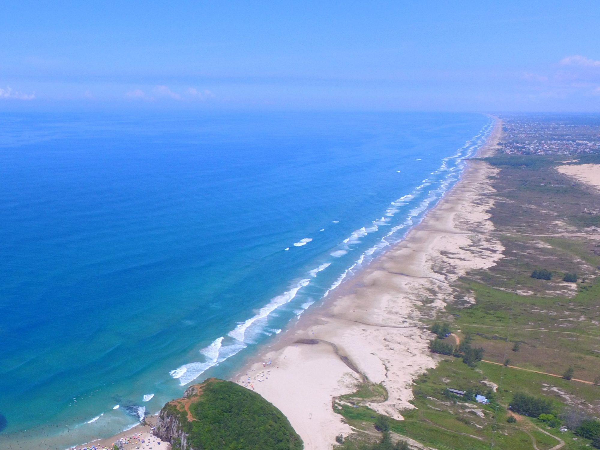 Mar aberto, dunas e a presença da área protegida de Itapeva no litoral de Torres.