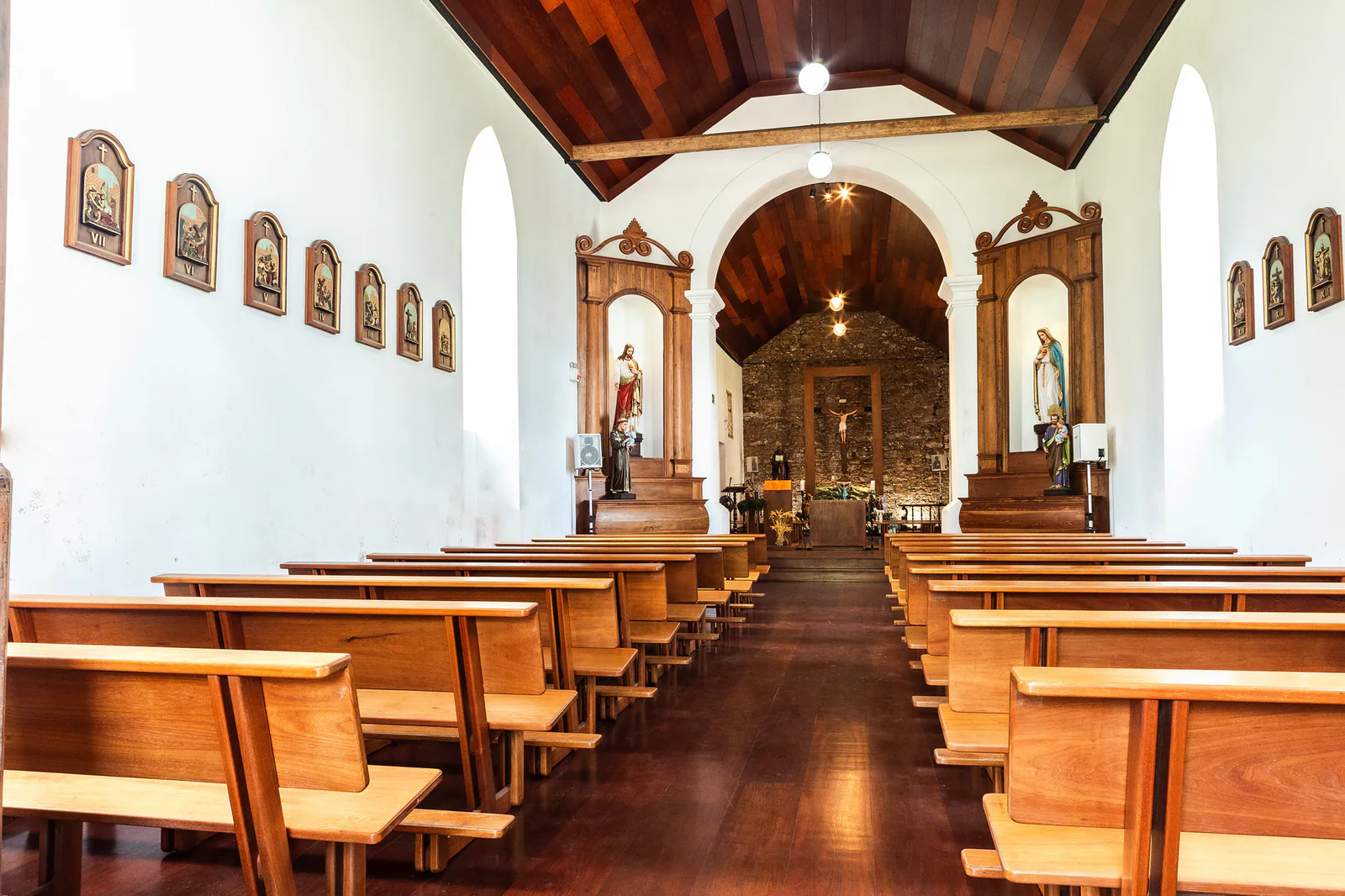 Interior de la Igreja Matriz São Domingos, con bancos de madera, imágenes religiosas y el altar al fondo