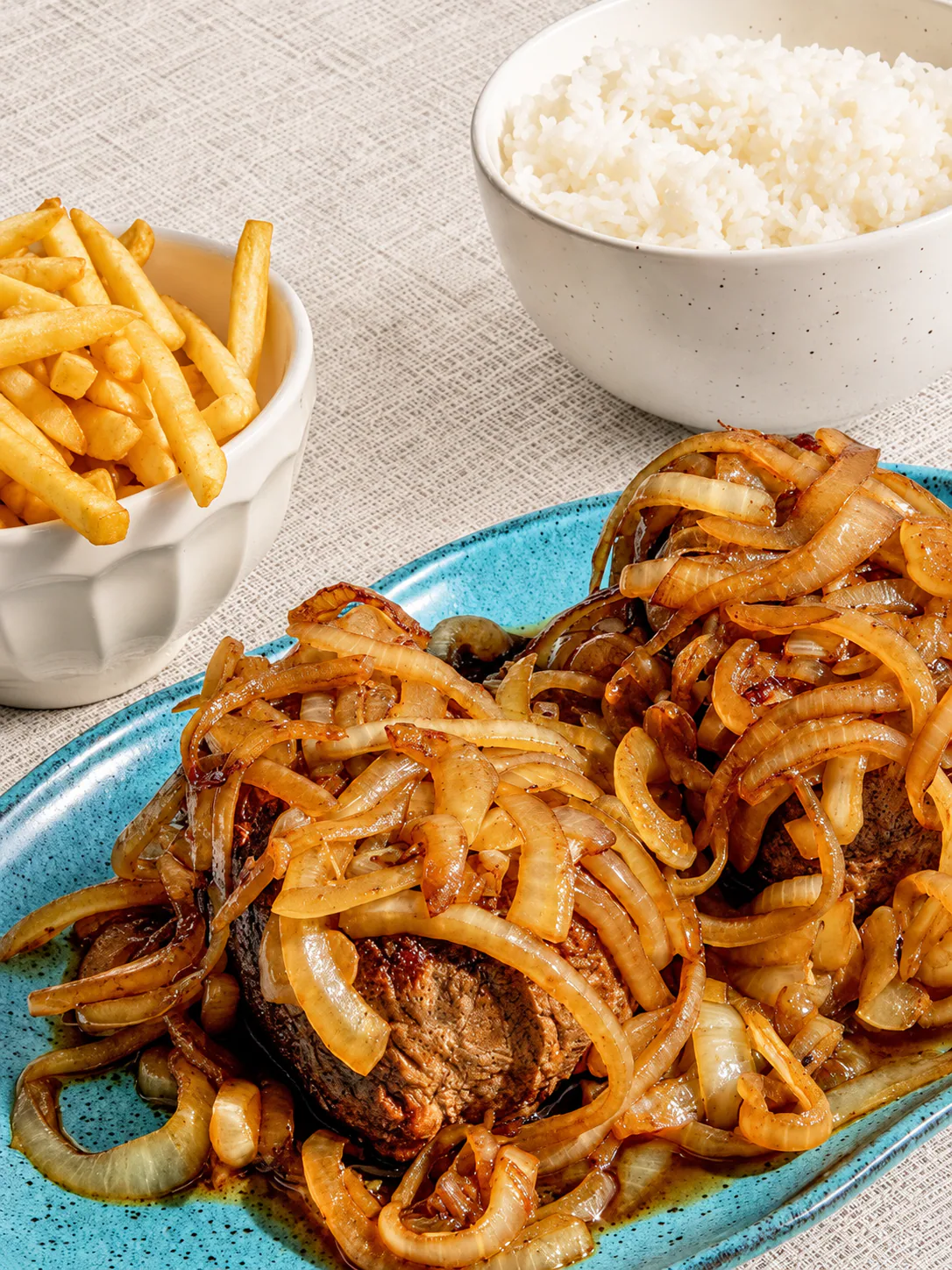 Carne acebolada acompanhada de arroz e batatas fritas