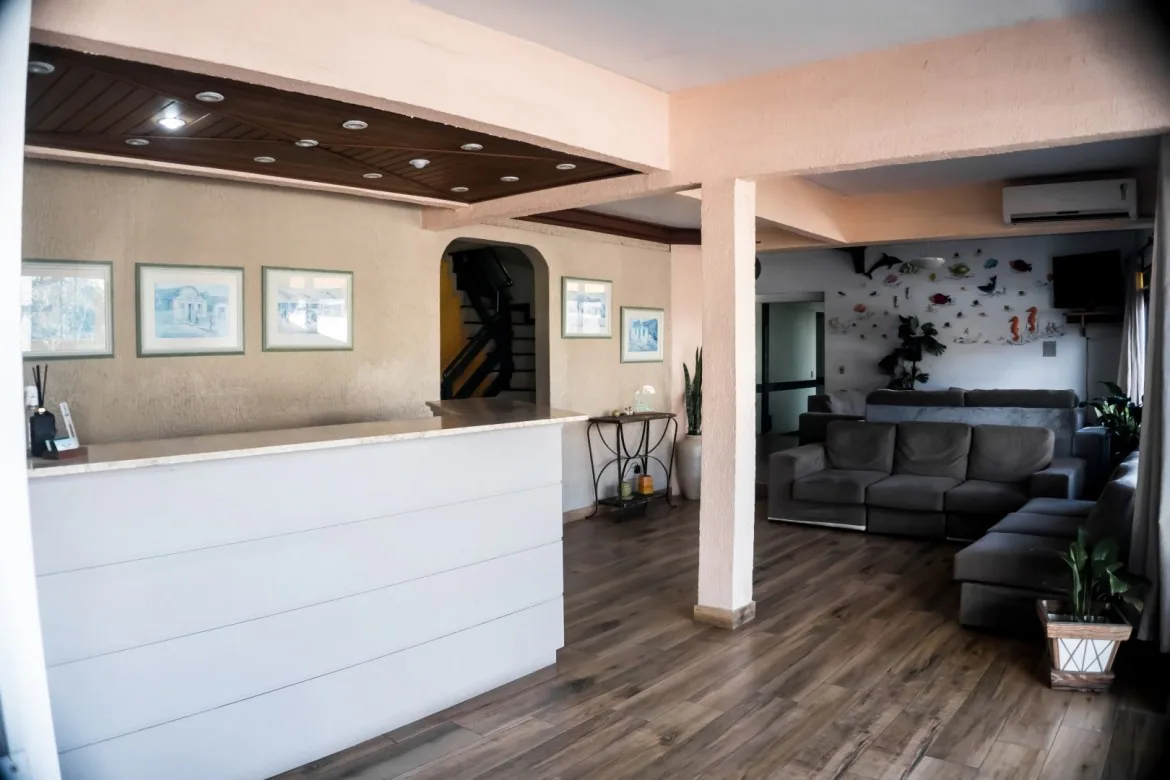 Recepção do Hotel Bauer com balcão branco e sala de estar