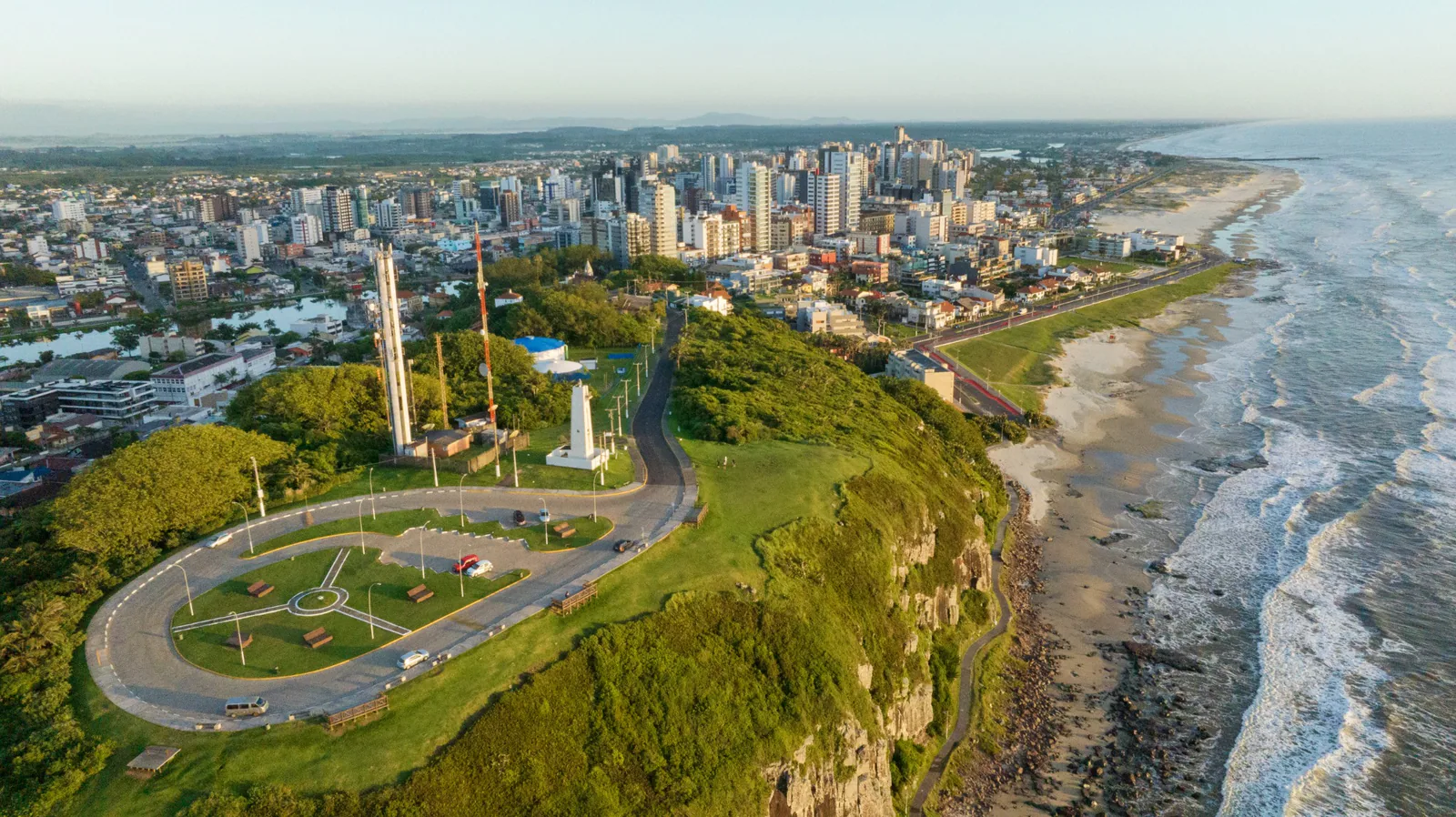 Vista aérea del faro y del mirador, con las playas y la ciudad al fondo